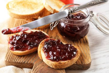 Kavanoz ve ahşap tahta üzerinde tatlı reçelli lezzetli tost