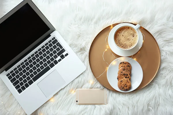 Laptop, mobile phone and tray with breakfast on fluffy carpet, top view — Stock Photo, Image