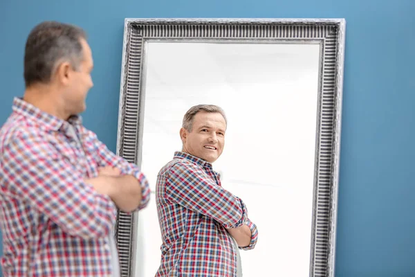 Homme mûr souriant debout près du miroir à la maison — Photo