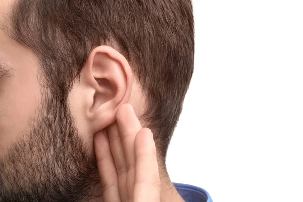 Молодой человек с проблемами со слухом на белом фоне, крупный план — стоковое фото