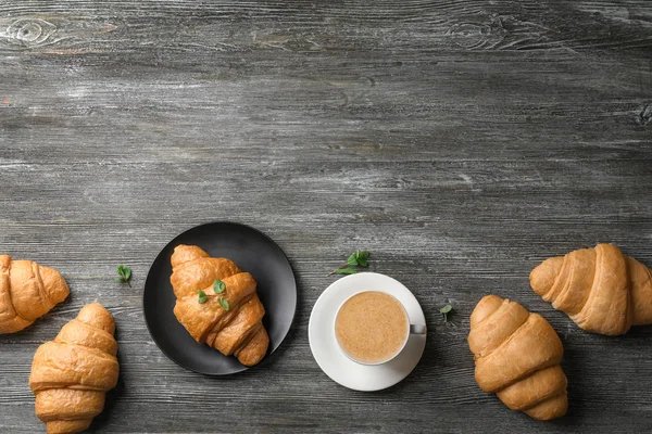 Croissants deliciosos com xícara de café na mesa de madeira — Fotografia de Stock