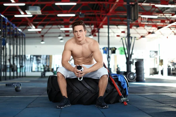 Ung muskulös man vilar på däck i gymmet — Stockfoto