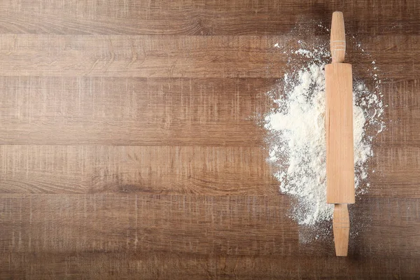 散乱の小麦粉と木製のテーブルに麺棒 — ストック写真