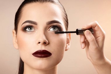 Kadının yüzüne karşı açık renkli makyaj uygulayarak profesyonel visage sanatçı