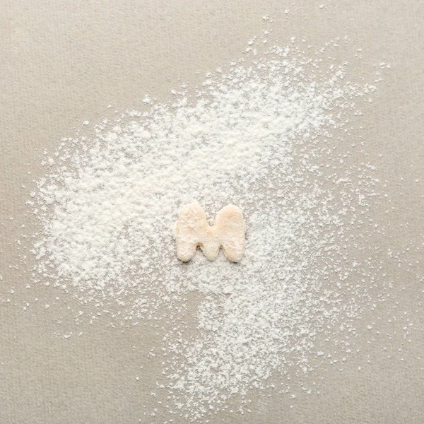 Lettera M fatta di pasta cruda su farina — Foto Stock