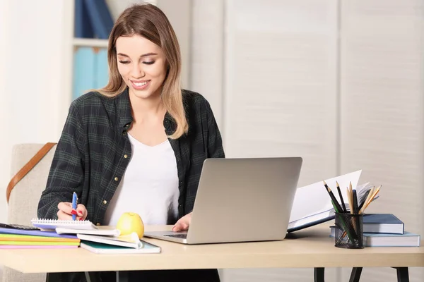 Ładny student z laptopa, studiuje w tabeli wewnątrz — Zdjęcie stockowe