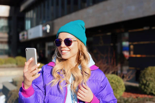 Ung kvinna i snygg outfit med mobiltelefon utomhus — Stockfoto