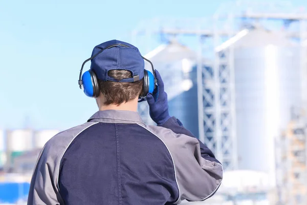 Hombre trabajador con auriculares al aire libre. Equipo de protección auditiva —  Fotos de Stock