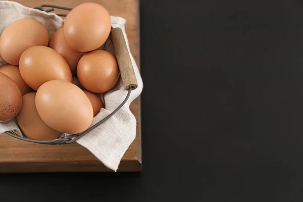 Cesta de metal con huevos de pollo en la mesa — Foto de Stock