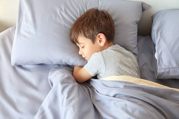 Bonito menino dormindo na cama em casa — Fotografia de Stock