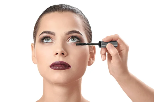 Professionele visage kunstenaar toepassing van make-up op het gezicht van de vrouw tegen de witte achtergrond — Stockfoto