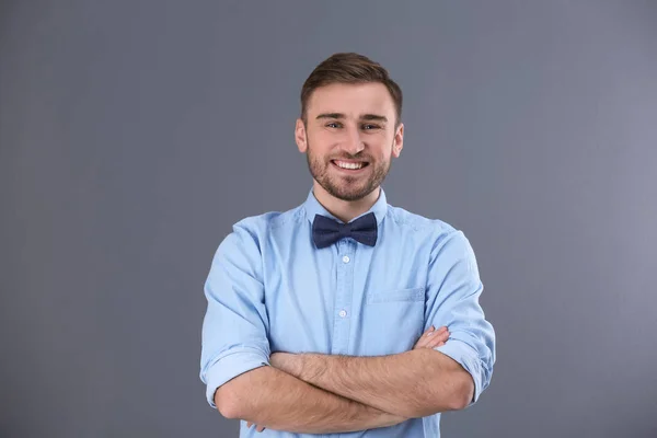 Hombre joven en ropa casual sobre fondo gris — Foto de Stock