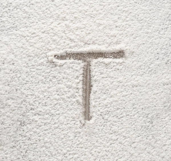 Letter T written on flour — Stock Photo, Image