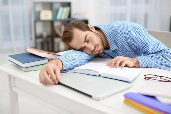 Estudante cansado estudando à mesa dentro de casa — Fotografia de Stock