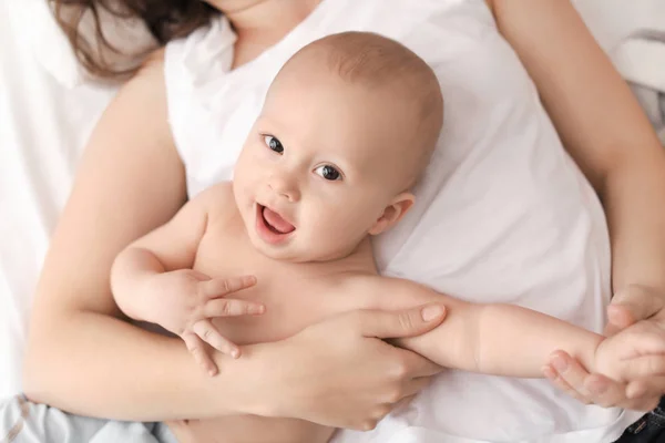 Young mother and her baby lying on bed at home — Stock Photo, Image