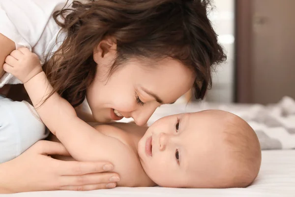Mladá matka a její dítě na posteli doma — Stock fotografie