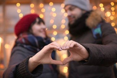 Genç sevgili çift kalp el ile açık havada kış gününde yapma