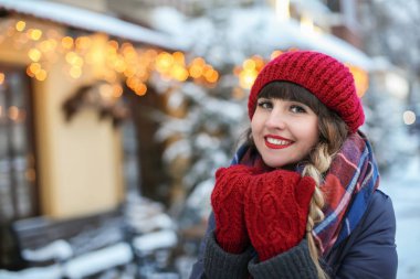 Kış günü açık havada şık sıcak giysiler içindeki genç kadın portresi