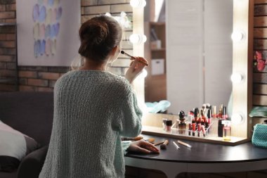 Güzel genç kadın makyaj odasında uygulamak