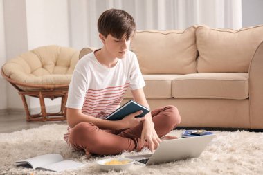 Ev ödevi kapalı dizüstü kullanarak sevimli genç çocuk