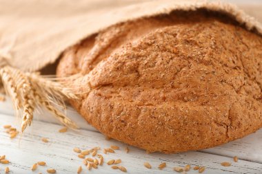 Taze pişmiş ekmek, buğday taneleri ve sivri masada