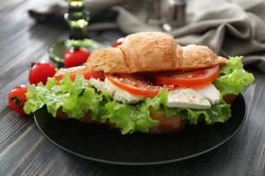 Plaka ile lezzetli kruvasan sandviç ahşap tablo