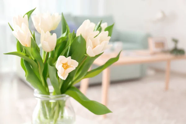 Vase with bouquet of tulips on blurred background — Stock Photo, Image