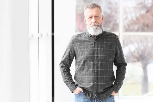 Portret van knappe volwassen man in de buurt van venster thuis — Stockfoto