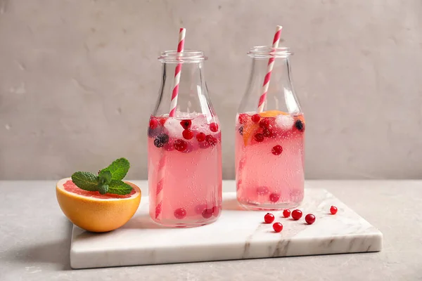 Chutnou limonádu s grapefruit a jahody v lahvích na stole — Stock fotografie