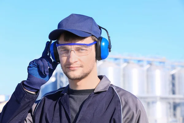 Trabalhador do sexo masculino com auscultadores ao ar livre. Equipamento de proteção auditiva — Fotografia de Stock