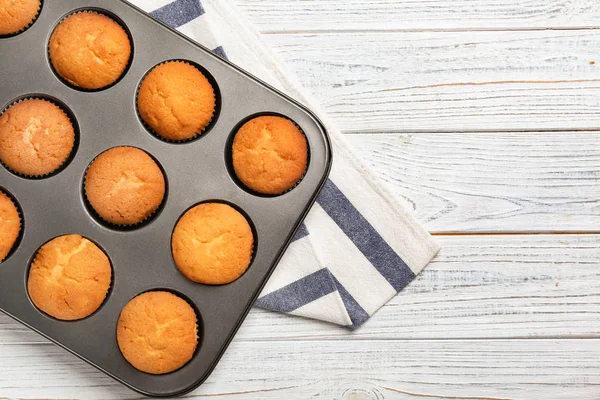 Bandeja de cozimento com cupcakes saborosos na mesa. Fresco do forno — Fotografia de Stock