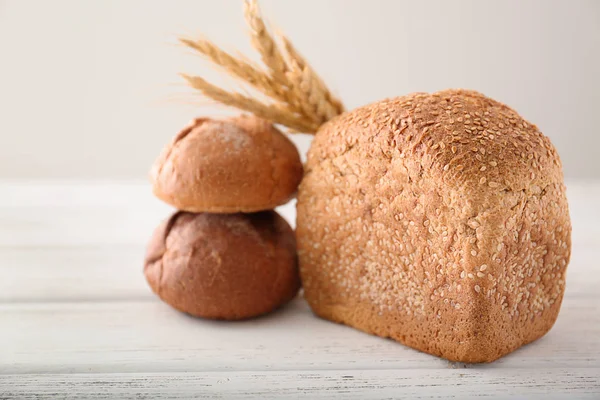 Nybakat bröd och bullar på bordet — Stockfoto