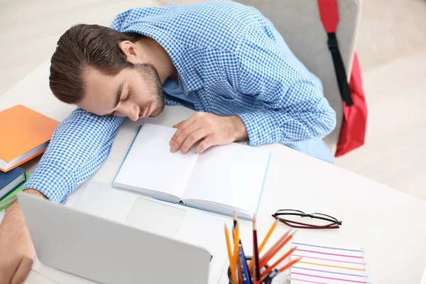 Уставший студент спит за столом в помещении — стоковое фото