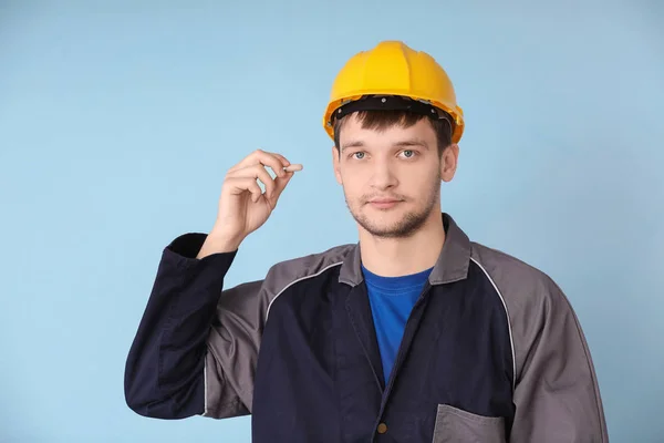 Male worker with earplug on grey background. Hearing protection equipment — Stock Photo, Image