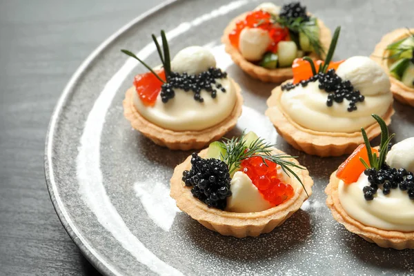 Sabrosos aperitivos de caviar negro en el plato — Foto de Stock