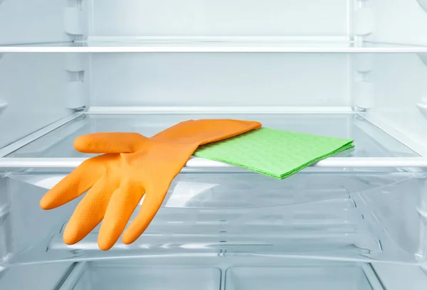 冰箱货架上的清洁抹布和防护手套 — 图库照片