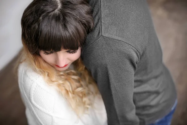 Junge Frau umarmt ihren Freund drinnen — Stockfoto