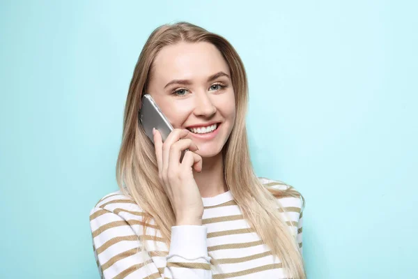 Bella giovane donna che parla sul telefono cellulare su sfondo a colori — Foto Stock