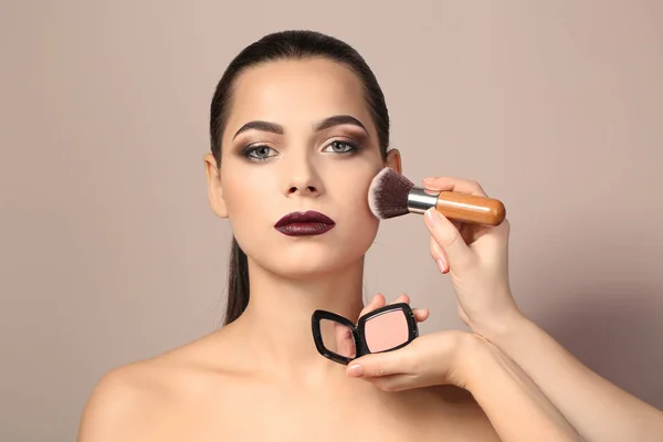 Kadının yüzüne karşı açık renkli makyaj uygulayarak profesyonel visage sanatçı — Stok fotoğraf