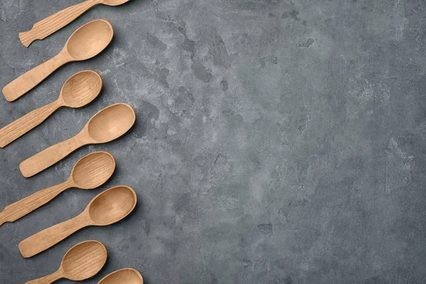 Wooden kitchen utensils on grey background