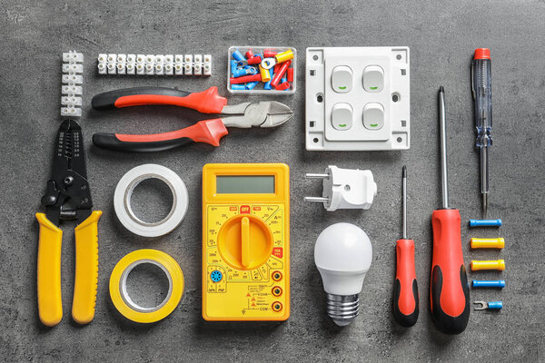 Different electrical tools on grey background