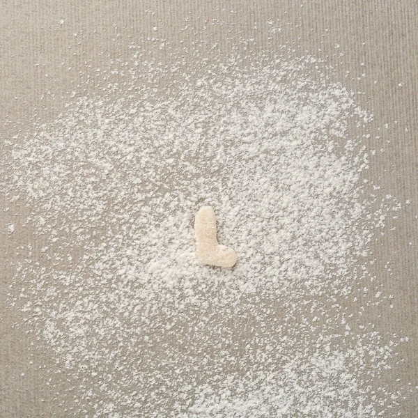 Letter L made of raw dough on flour — Stock Photo, Image