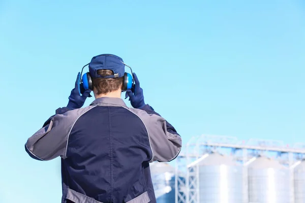 Hombre trabajador con auriculares al aire libre. Equipo de protección auditiva —  Fotos de Stock