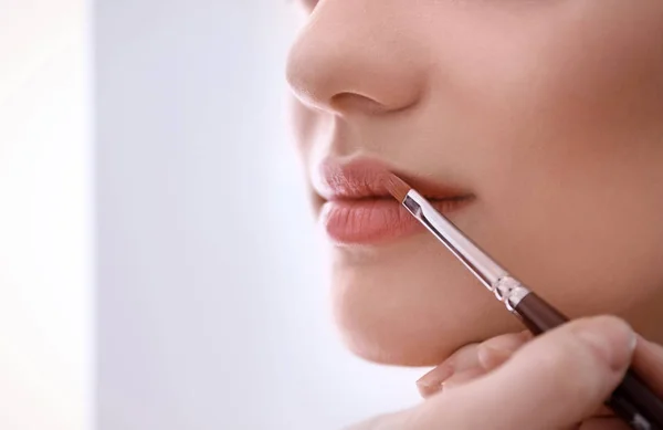 Professional makeup artist working with woman, indoors — Stock Photo, Image