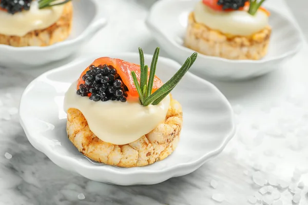 Aperitivo saboroso com caviar preto e salmão na placa — Fotografia de Stock