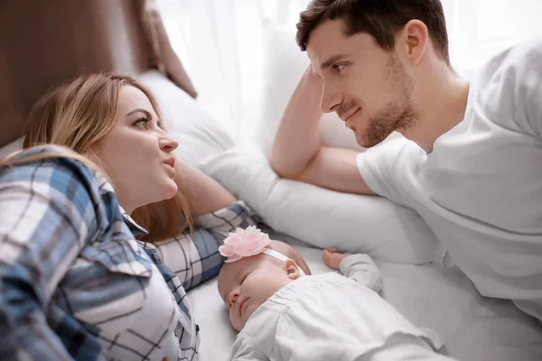 집에서 침대에 귀여운 잠자는 아기와 젊은 부모 — 스톡 사진