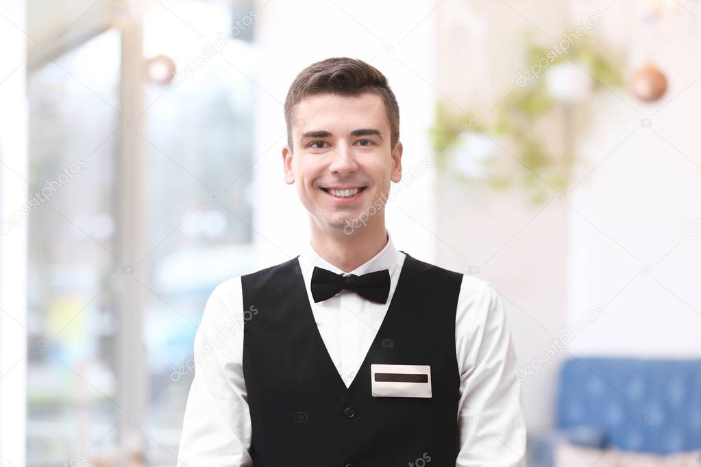 Attractive young waiter at workplace