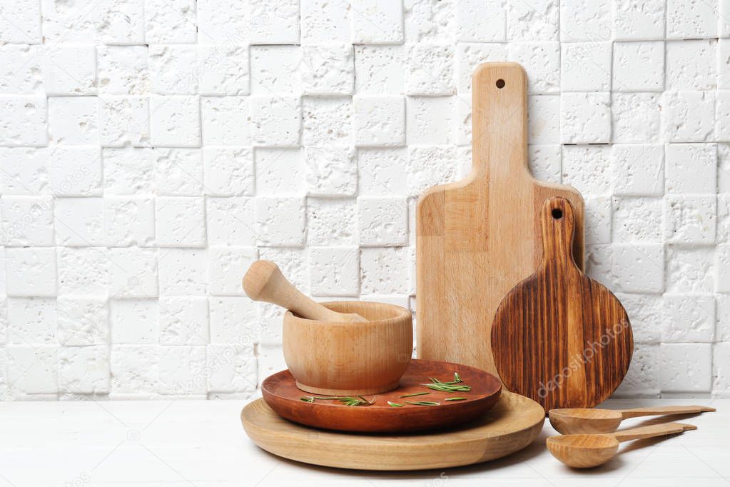 Set of kitchen utensils on table against white wall