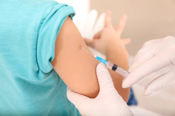 Médico vacunando a un niño pequeño en la clínica, primer plano —  Fotos de Stock