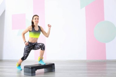 Güzel genç bir kadın evde spor yapıyor.